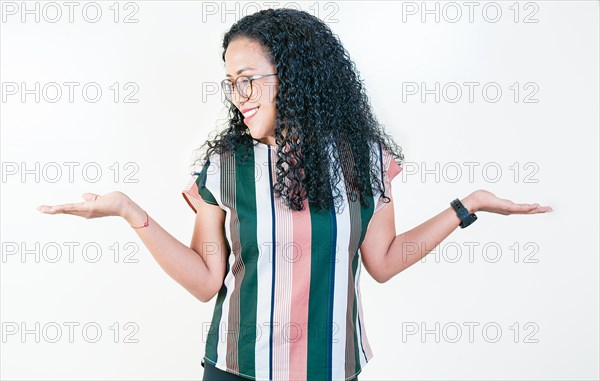 Young afro girl balancing something with palms isolated. Smiling afro woman comparing with palms with hands isolated