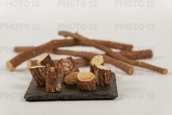 Group of sliced natural licorice roots on a black slate and white background