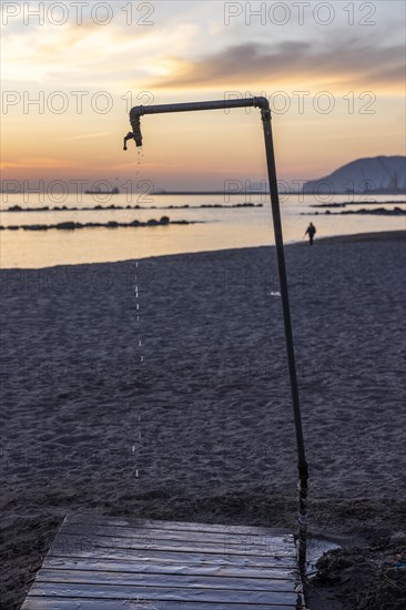 Dripping shower at sunset on the beach