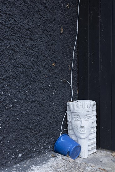 Bizarre still life with a sphinx from the hardware store and a blue bucket