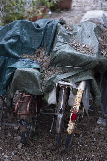 Rusty bicycles covered with a tarpaulin at an out-of-season campsite