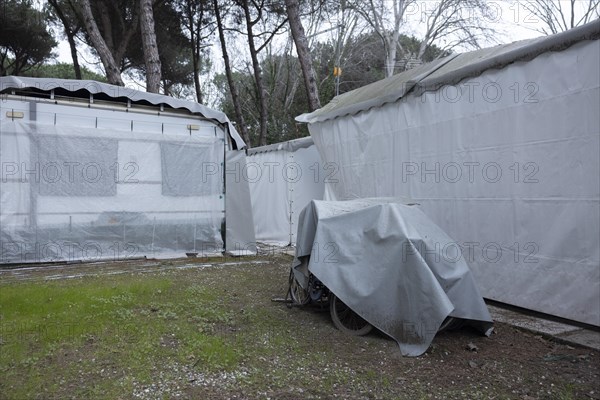 Rusty bicycles covered with a tarpaulin at an out-of-season campsite