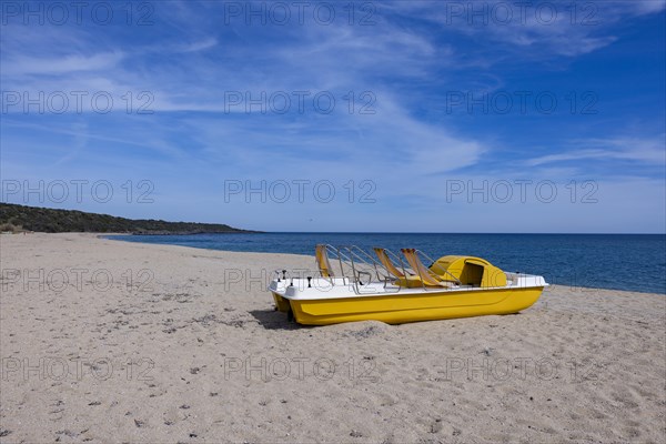 Yellow pedal boat on the beach with blue sky and blue sea