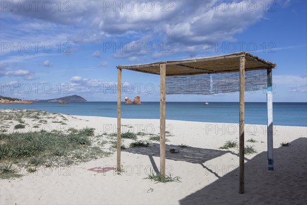 White hut with thatched roof on a white sandy beach and blue sea