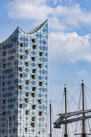 Mast of a sailing ship in front of the façade of the Elbe Philharmonic Hall