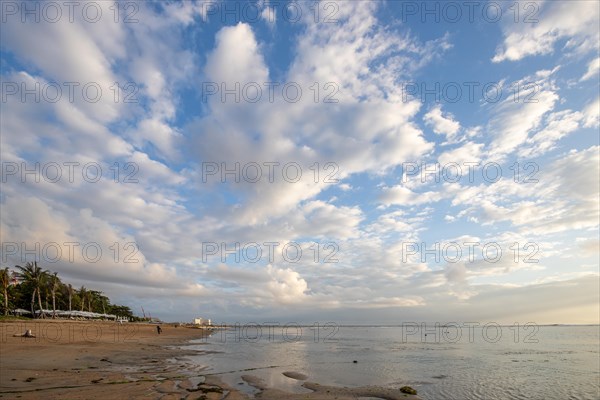 Sunrise on the sandy beach. Landscape shot with a view of the sea and the beach. Waves of light and a morning atmosphere that only exists in Sanur