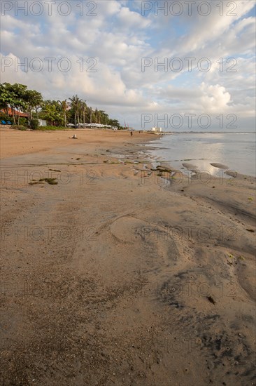 Sunrise on the sandy beach. Landscape shot with a view of the sea and the beach. Waves of light and a morning atmosphere that only exists in Sanur