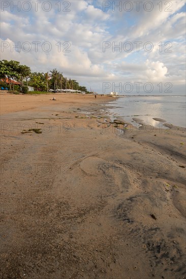 Sunrise on the sandy beach. Landscape shot with a view of the sea and the beach. Waves of light and a morning atmosphere that only exists in Sanur
