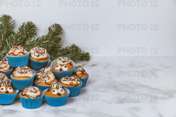 Muffins in blue ramekins with chocolate icing and sugar sprinkles