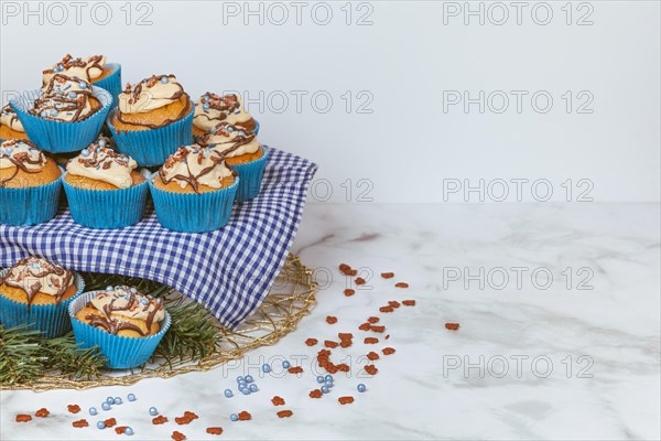 Cupcakes in blue ramekins with chocolate icing and sugar sprinkles