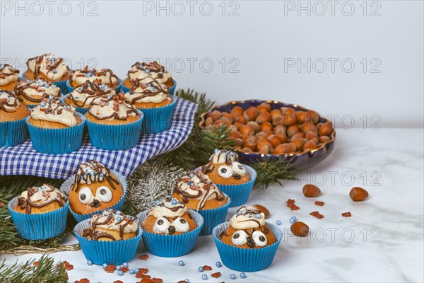 Cupcakes in blue ramekins with chocolate icing and sugar sprinkles