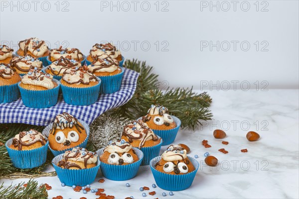 Cupcakes in blue ramekins with chocolate icing and sugar sprinkles
