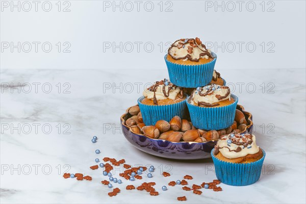 Muffins in blue ramekins with chocolate icing and sugar sprinkles