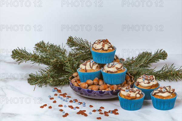 Muffins in blue ramekins with chocolate icing and sugar sprinkles