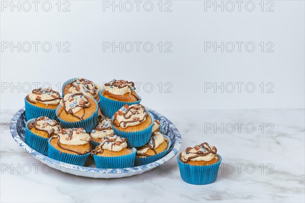 Cupcakes in blue ramekins with chocolate icing and sugar sprinkles