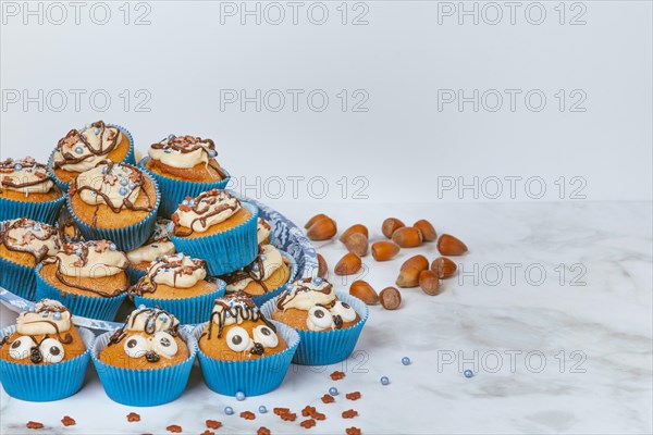 Muffins in blue ramekins with chocolate icing and sugar sprinkles