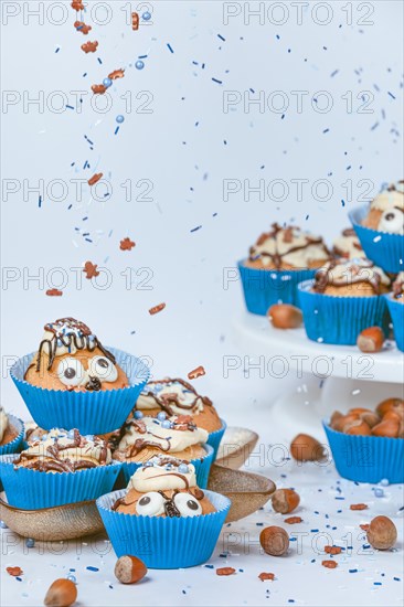 Cupcakes in blue ramekins with chocolate icing and sugar sprinkles