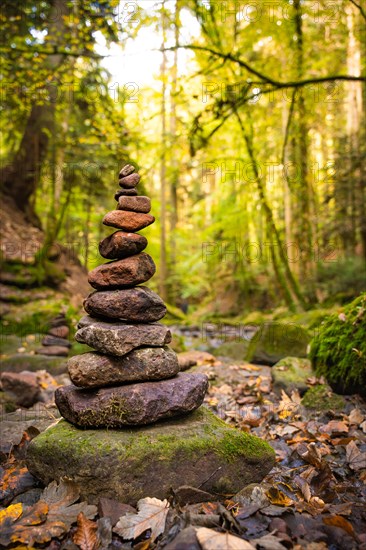 Stone man on hiking trail through autumn forest