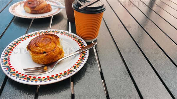 Cinnamon buns and hot coffee in a paper cup