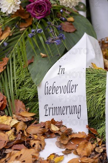 Mourning ribbon with inscription In loving memory on a memorial tree with the names of those buried there in Seelwald