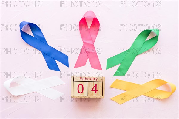 4th february wooden box around colorful ribbons pink background