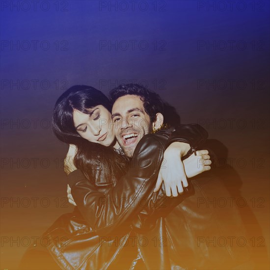Attractive lady hugging laughing guy leather jackets