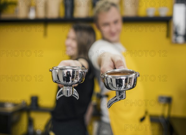 Baristas posing back back while holding cups