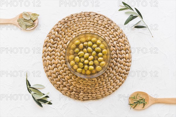 Bowl with olives oil herbs white background