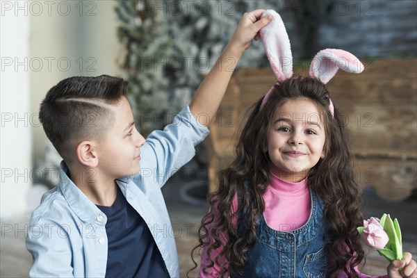 Boy looking girl bunny ears with tulip