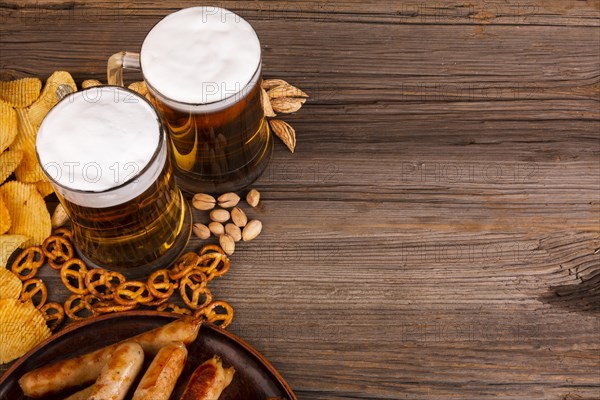 Close up beer with snacks wooden table