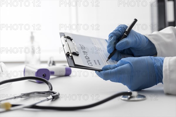 Close up doctor filling covid medical form