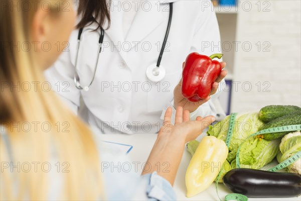 Close up doctor patient with vegetables