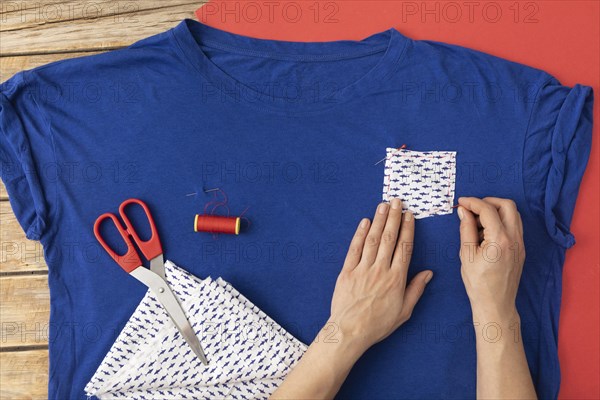 Close up hands sewing fabric shirt