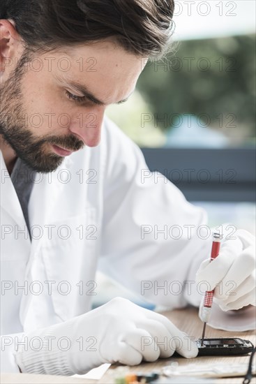 Close up male technician repairing cellphone