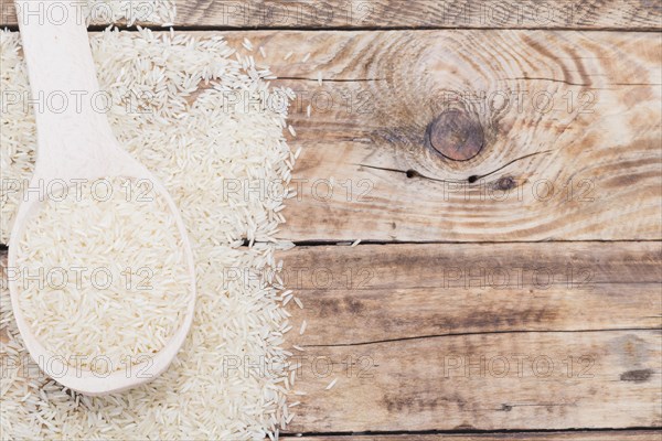 Close up raw white rice spoon textured plank