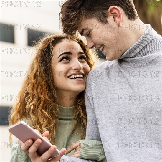 Close up smiley couple with smartphone