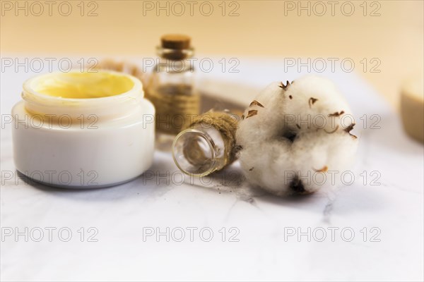 Close up spa cream bottle with cotton flower