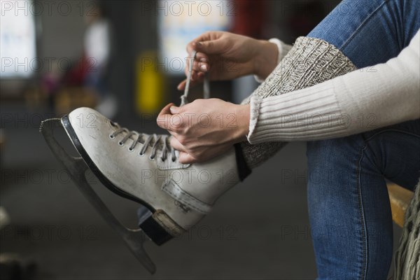 Crop hands tying laces ice skates