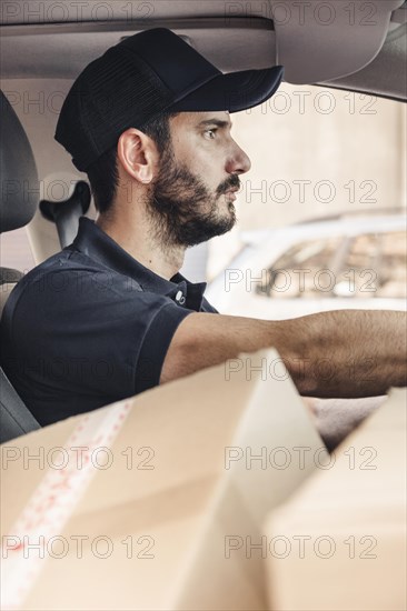 Delivery man with cardboard boxes driving vehicle