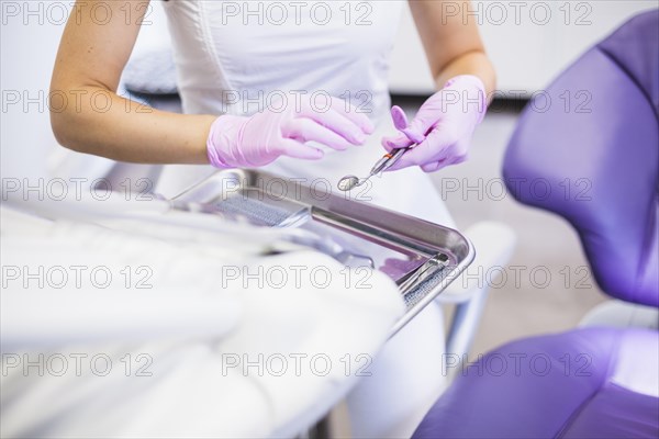 Dentist s hand holding dental mirror clinic