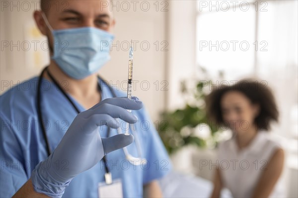 Doctor holding syringe with vaccine patient