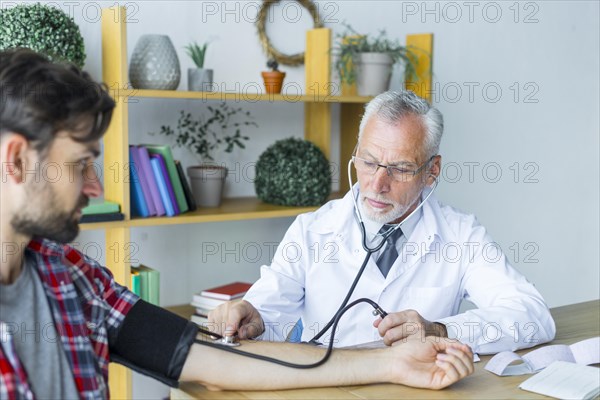 Doctor measuring blood pressure young patient
