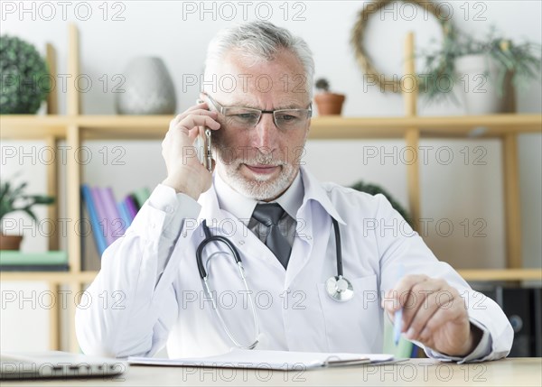 Doctor speaking phone office