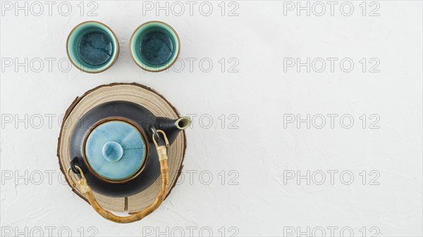 Earthenware teapot with tea cups isolated white background