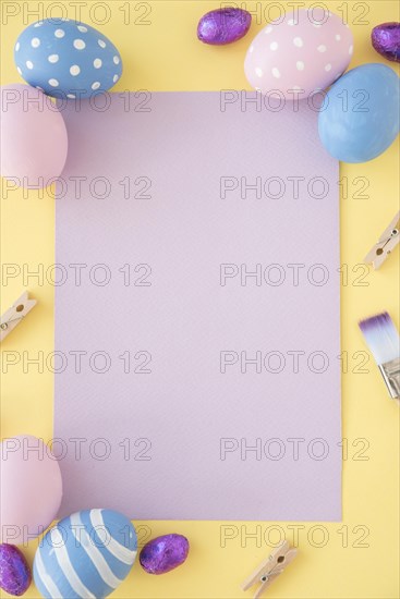 Easter eggs with blank paper yellow table