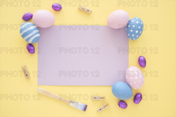 Easter eggs with blank purple paper yellow table