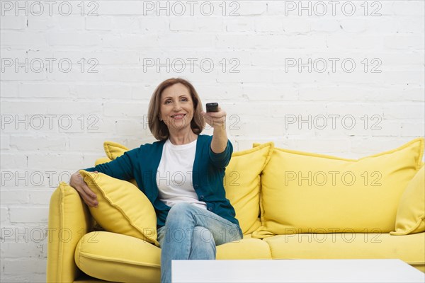 Elderly woman changing television channels