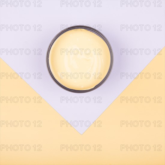 Elevated view yellow paint container dual paper background