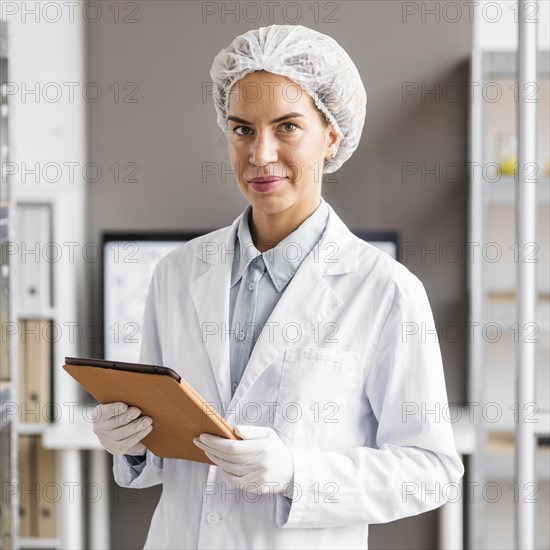 Female researcher biotechnology laboratory with tablet