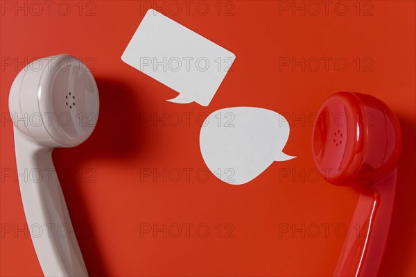Flat lay chat bubbles with two telephone receivers